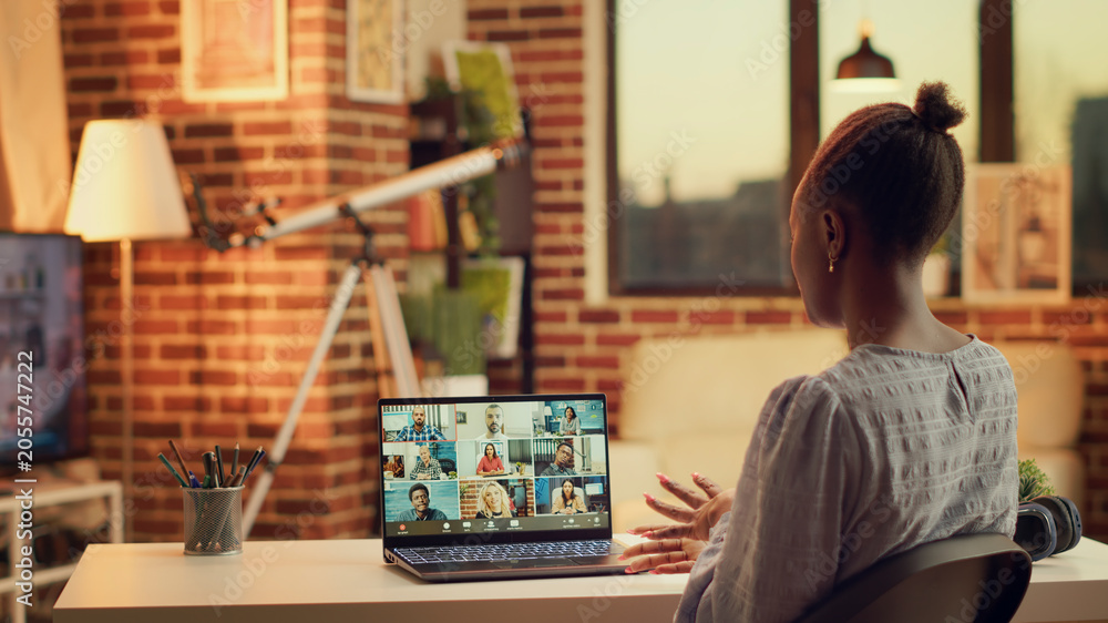 Fototapeta premium African American girl on videocall doing briefing meeting for new research plan to solve online tasks.