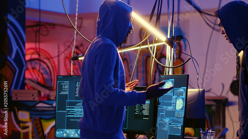 Fotografia Rogue hacker group leader welcoming new member in hidden underground base, ready to teach him how to get past anti tamper measures implemented by
