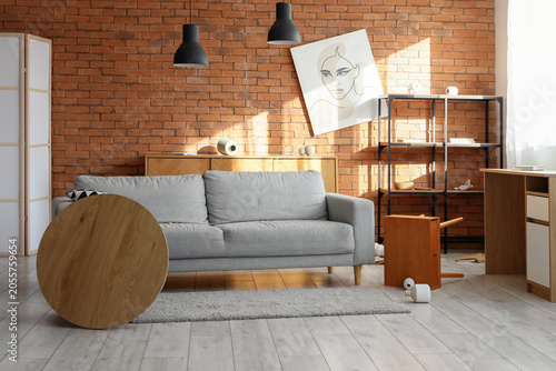 Tableau sur toile Messy living room interior with overturned furniture and scattered items, chaos