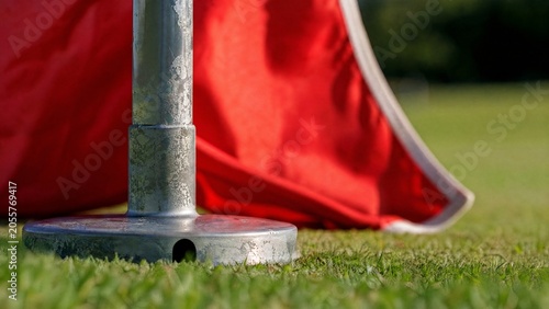 Close-up of metal flagstick base showing weathered texture against vibrant flag.
