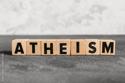Foto Atheism word on wooden blocks, belief system and philosophy concept, non-religio