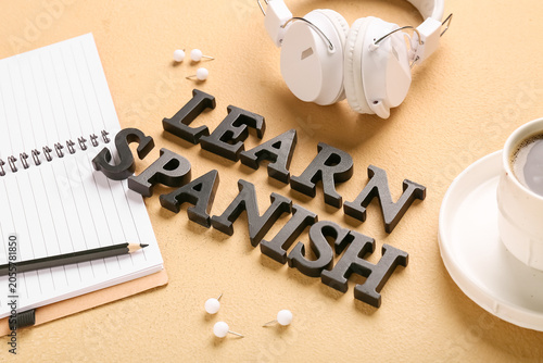 Fotografija Learn spanish language education with headphones, notebook, and coffee for onlin
