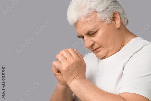 Senior man praying with cla...