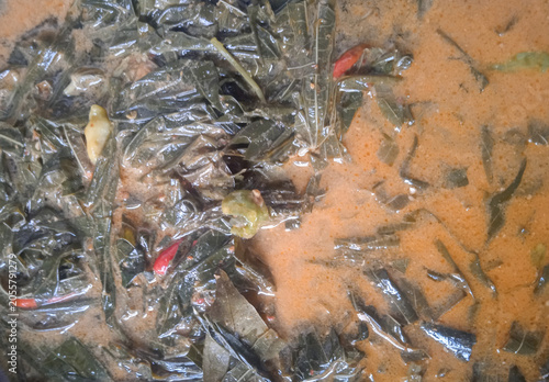 cassava leaves cooked with coconut milk in a wok