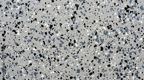 Textured epoxy resin floor surface featuring scattered black white and blue decorative flakes providing a modern durable industrial flooring finish