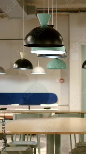 Vertical video: Panning camera capturing pendant lamps in lounge, highlighting black turquoise dome