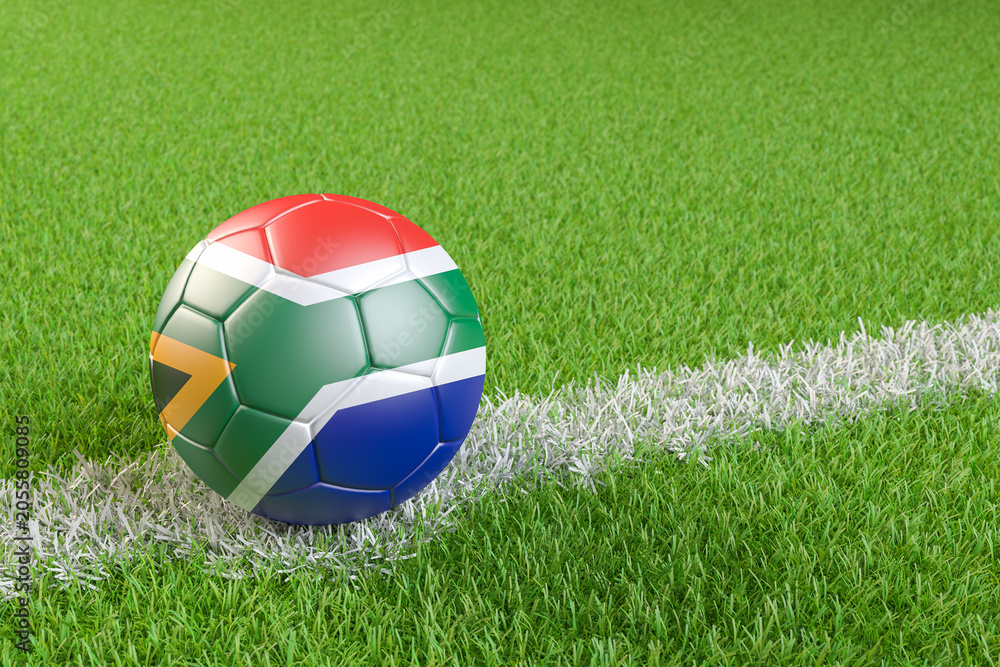 Naklejka premium Football / soccer ball with a flag overlay of South Africa on a football pitch background. International match and national team of South Africa concept