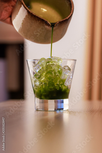 Pouring Matcha Over Ice Cubes