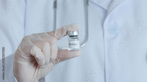 Quadro su tela Hopeful doctor wearing glove holding peptide vial for medical therapy treatment