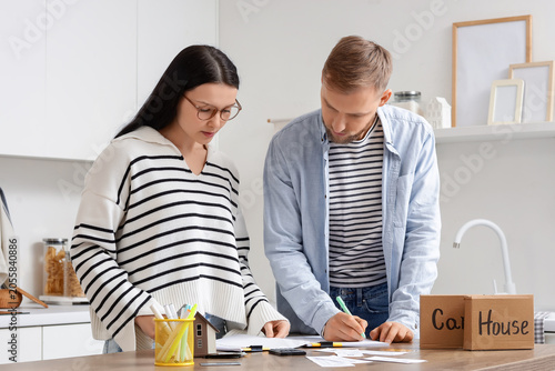 Young couple planning budget in kitchen