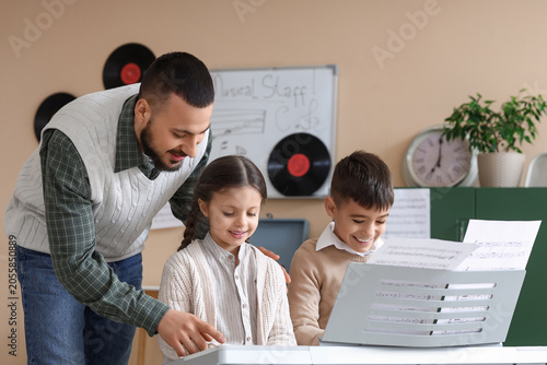 Music teacher guiding young...