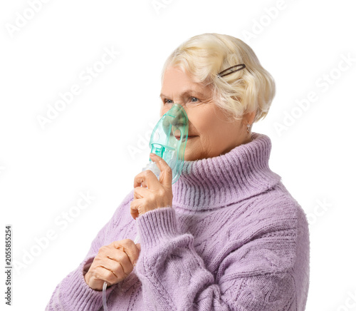 Senior woman using nebulize...