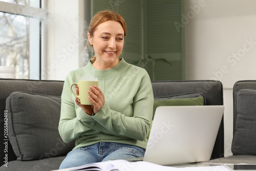 Smiling woman enjoying hot ...