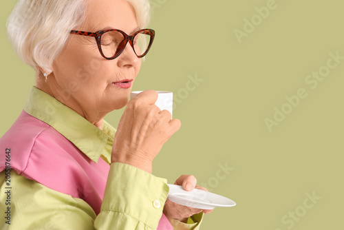 Stylish senior woman drinki...