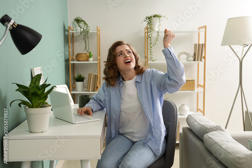 Slika na platnu Young woman suffering from noisy neighbours near desk at home