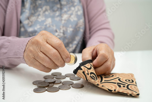 Fotografie Asian senior or elderly old lady woman holding counting coin money in bag
