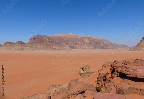 Stunning panoramic view of the red sand dunes and rocky mountains in wadi rum desert jordan under a clear blue sky