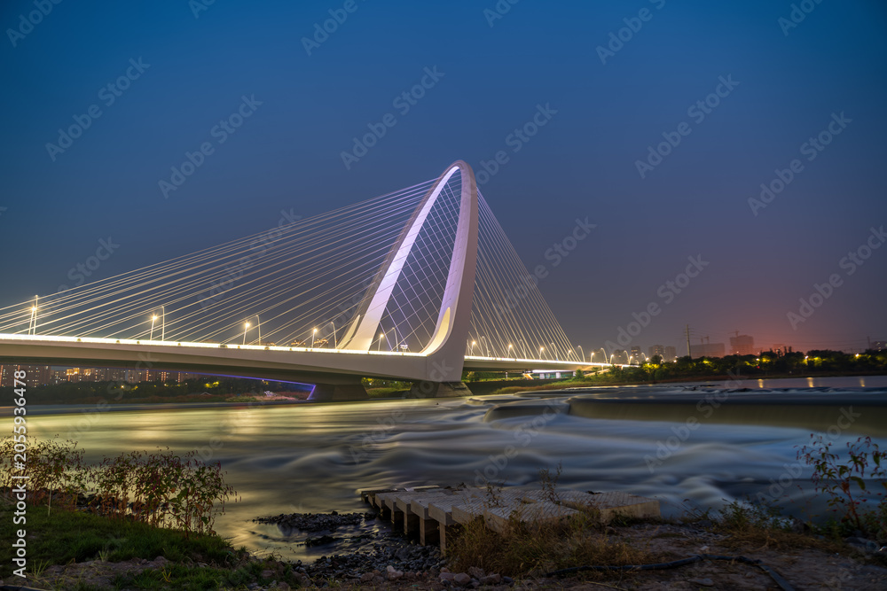 Fototapeta premium Night view of Shougang Bridge, a modern bridge landmark in Beijing, China.