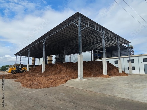 Foto Woodchip storage facility with industrial warehouse and biomass fuel stockpile