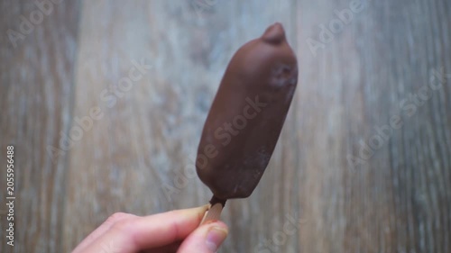 Ice cream double milk chocolate coating, caramel sauce filling stick bar hand holding sweet dessert food treat in summer