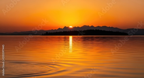 Vibrant golden sunset over calm lake with mountain silhouette