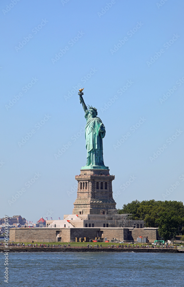 Fototapeta premium iconic statue of liberty symbol of freedom with raised torch representing american democracy viewed from the sea