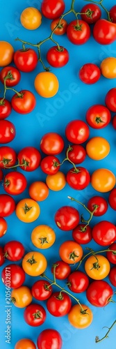 Cherry tomatoes scattered on a blue background with minimal yellow tomatoes, pattern, colorful
