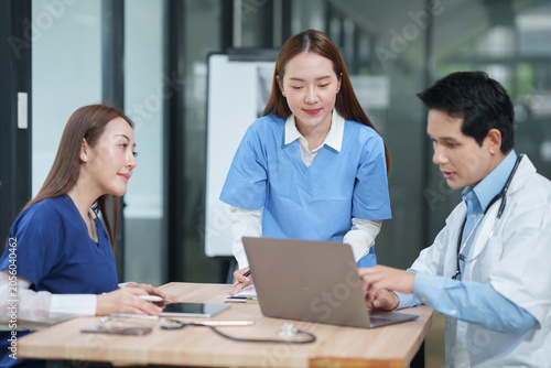 Medical Team Discussing Patient Case on Laptop in Hospital