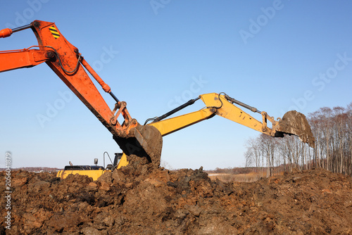 Construction - Closeup two Excavators work in dirt