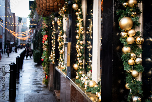 Obraz na płótnie Decorated storefront with gold ornaments and holiday lights in a city street dur
