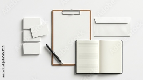 A neatly arranged workspace with office supplies including a clipboard, notebook, envelopes, and sticky notes on a clean white desk.