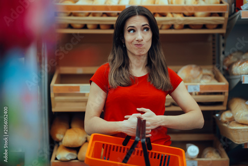 Fotografía Gluten Intolerant Woman in front of Bakery Shelf Touching her Belly