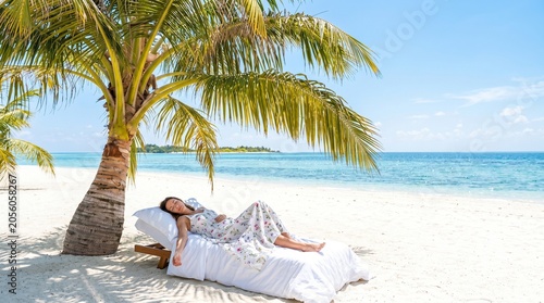 Young Woman Relaxing on Beach Bed Beneath Palm Tree in Tropical Island Paradise