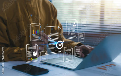 Businessman reviewing digital documents on laptop with virtual document management system, workflow automation, compliance verification, data reporting, paperless office and productivity solutions.