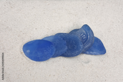 Bright Blue Sea Glass Stacked on White Sand Beach