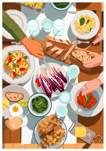 Top-down view of people sharing a delicious dinner with pasta, bread, salad, and wine around a rustic table.