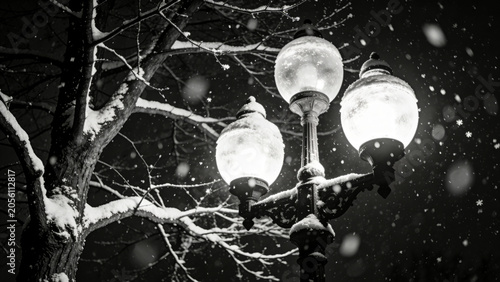 Snowy winter scene featuring vintage street lamps illuminated against falling snowflakes and bare tree branches