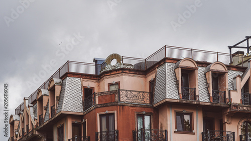 Foto Old classic building roof with mansard windows and metal railings at dusk