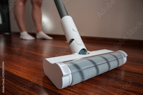 Fotografia Woman in white socks cleaning living room for perfect home hygiene and spotless lifestyle