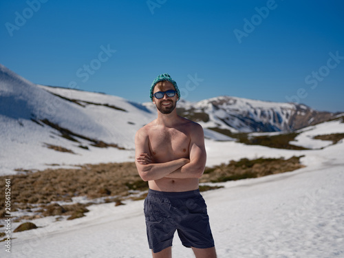 Canvas Print Smiling shirtless man practicing hardening on snowy slope in Carpathians