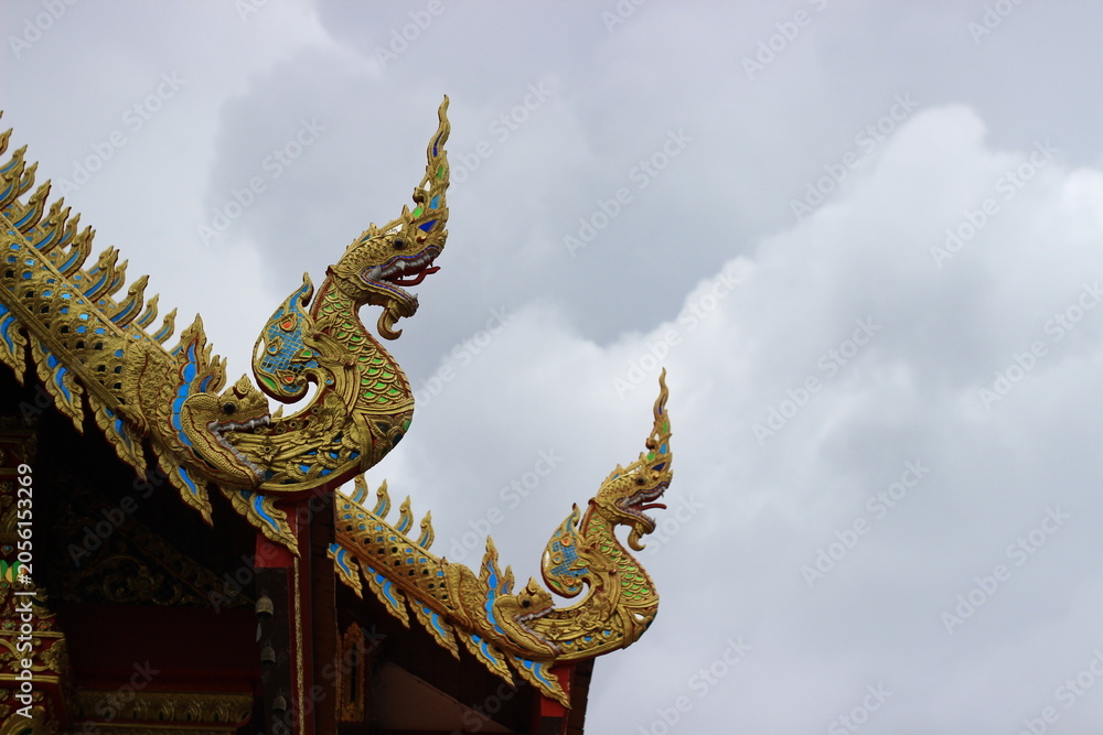 Fototapeta premium The temple roof features beautiful Naga (serpent) motifs.