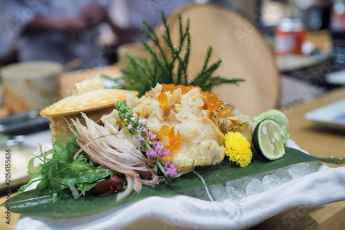 Fotografija Plate of fresh sliced whelk Tsubugai sashimi (Sazae) served with salmon roe