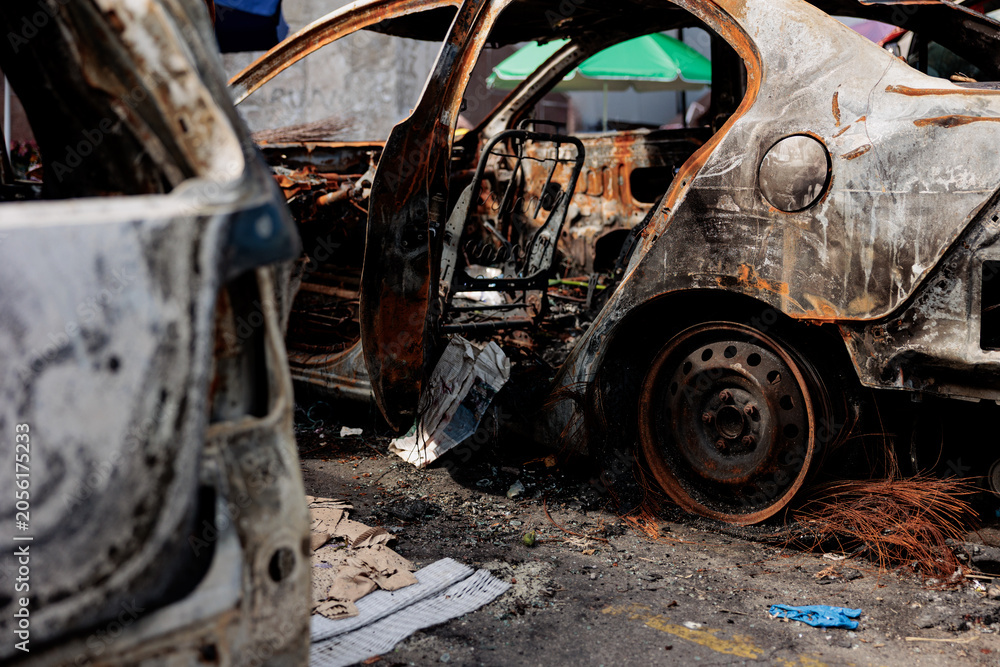 Fototapeta premium A burnt-out car as a result of Russia's missile strike against Ukraine. Car hit by shrapnel