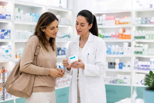 Pharmacist advising customer about medicine in drugstore