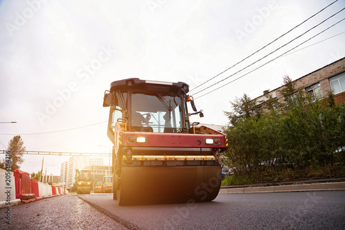 Obraz na płótnie Road Roller Compacting Fresh Asphalt on a City Street During Daytime Constructio