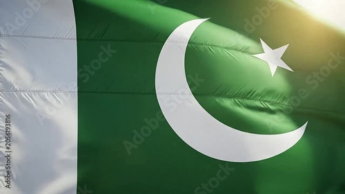 A green and white flag with a crescent moon and star symbol waving in the wind