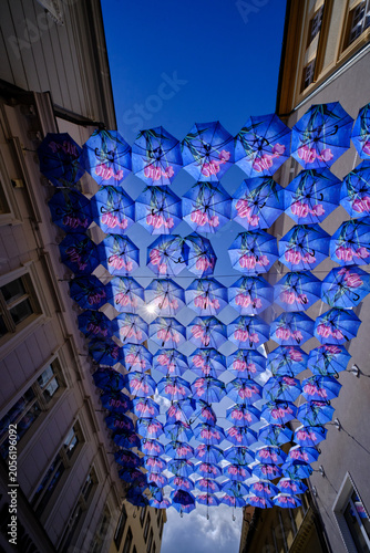 Blue umbrellas above the street between buildings