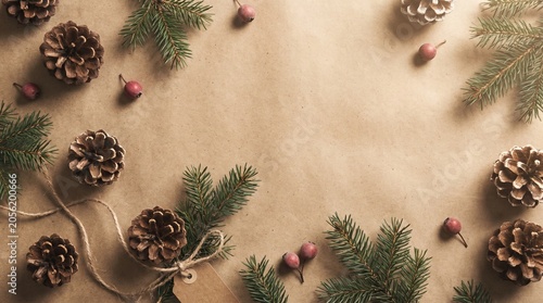 Festive pinecones and holiday greens arranged on kraft paper background  