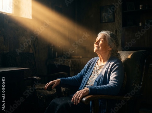 Elderly woman sitting in a chair with sunlight.
