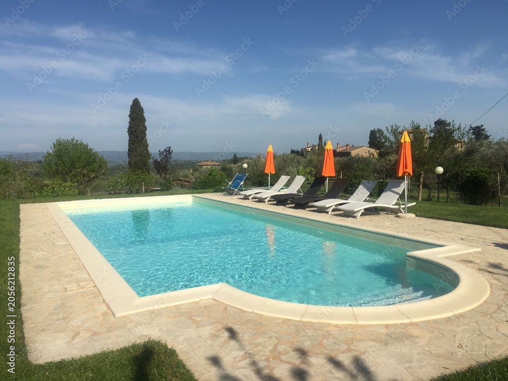 Naklejka premium Luxury Swimming Pool with Sun Loungers in the Tuscan Countryside